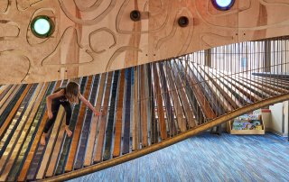child on colorful wooden climber at the Children's Museum of Tacoma